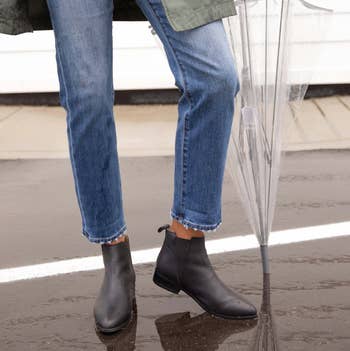 model wears same boots with jeans while walking in the rain