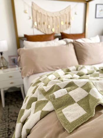reviewer's sage green checked blanket on a bed