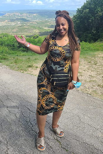 Reviewer outside in camouflage dress and sandals with black quilted fanny pack around their waist 