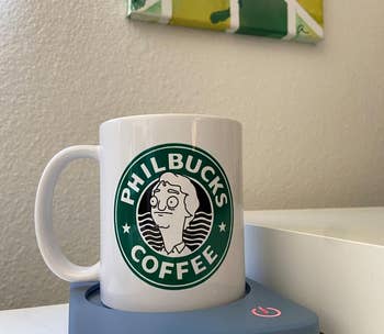 reviewer's Philbucks' Coffee mug on the blue warmer
