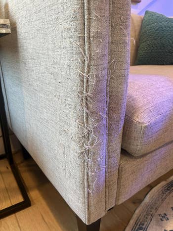 Couch with frayed cloth  connected  the armrest, placed successful  a surviving  country   mounting  with a decorative pillow nearby