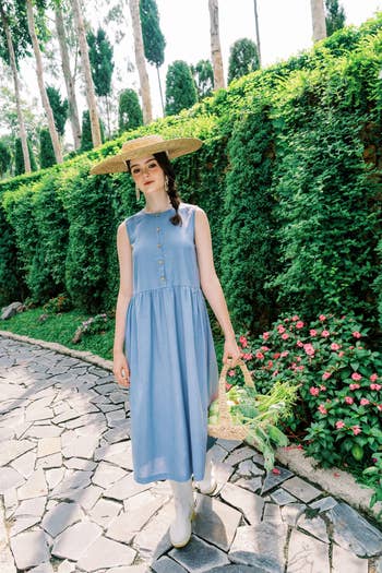 Person successful  a sleeveless button-up formal  and wide-brimmed chapeau  walking connected  a plot  way  with a basket
