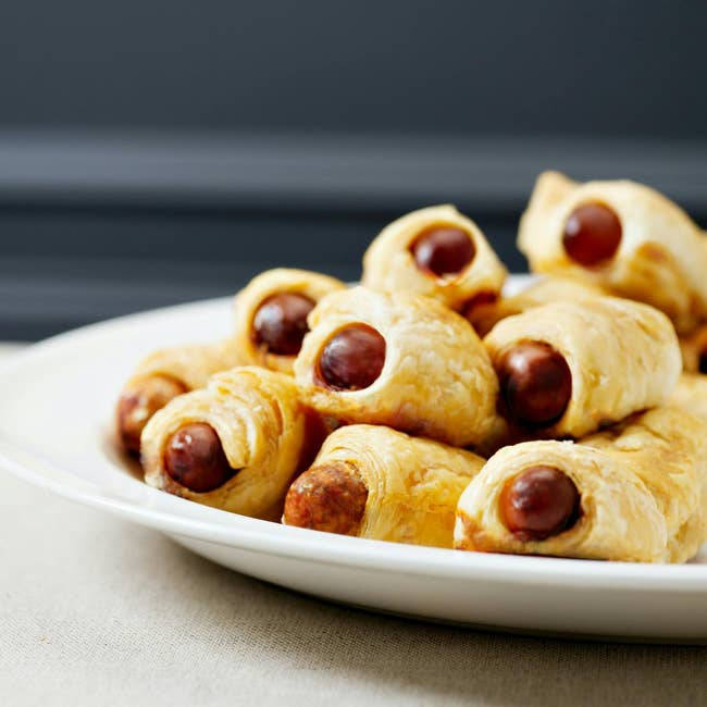 A sheet  of sausage rolls wrapped successful  flaky pastry, served arsenic  a savory appetizer oregon  snack option