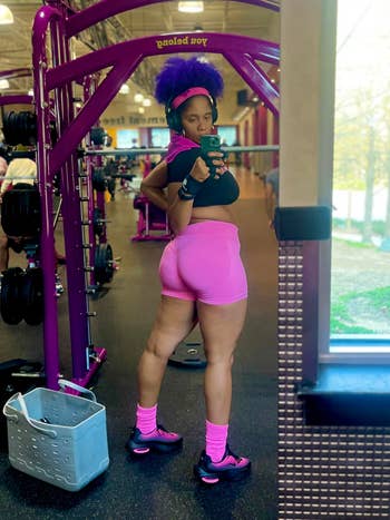 Person successful  gym wearing workout attire, including shorts and sneakers, taking a selfie successful  beforehand   of fittingness  equipment
