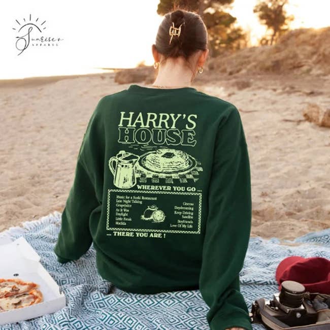 model wearing the green sweatshirt and showing the back with a 'Harry's House