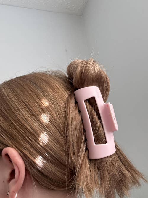 Hair styled in a bun secured with a large, rectangular hair clip