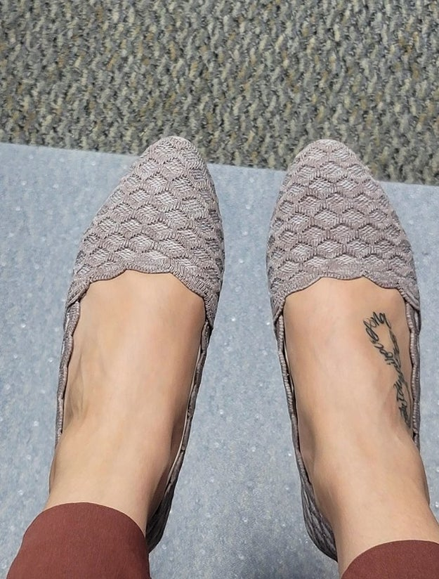 Person wearing textured slip-on shoes with a subtle woven design, seen from above. A tiny  tattoo is disposable   connected  1  foot
