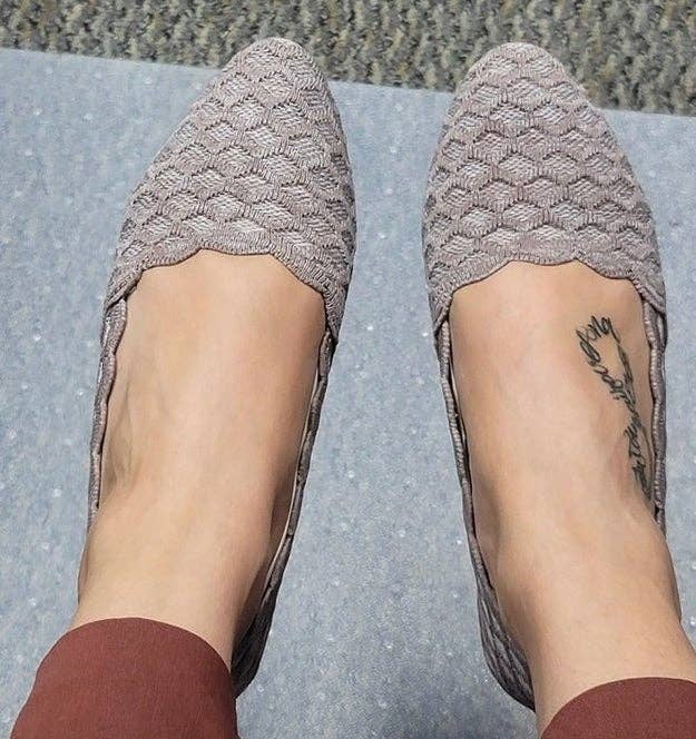 Person wearing textured slip-on shoes with a subtle woven design, seen from above. A tiny tattoo is disposable connected 1 foot