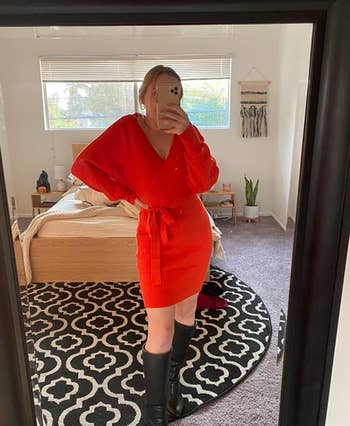 reviewer wearing orange dress