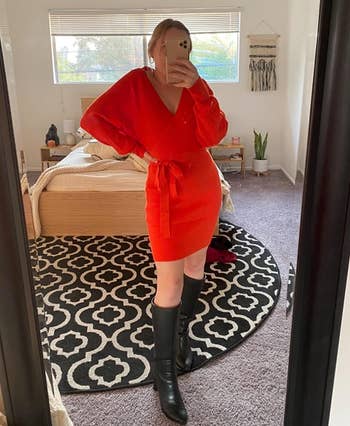 reviewer wearing orange dress