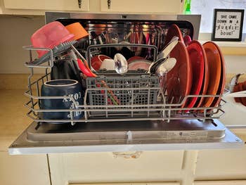 The inside of the dishwasher showing a lot of dishes fitting inside it