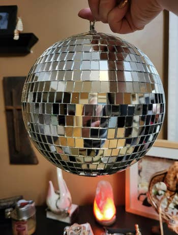 A reviewer holding a small disco ball 
