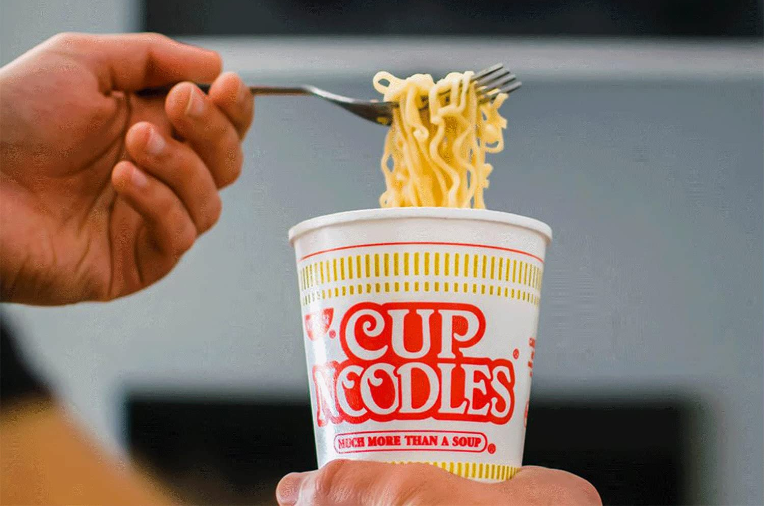 person eating cup noodles