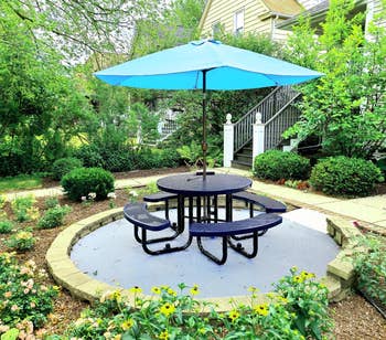 reviewer photo of round picnic table with umbrella in backyard
