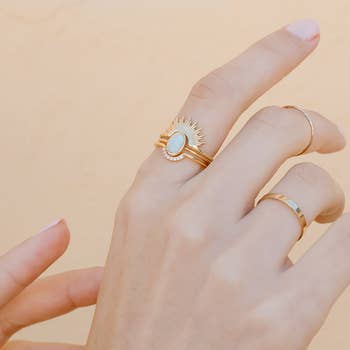 model wearing the rings in gold with white crystal arch