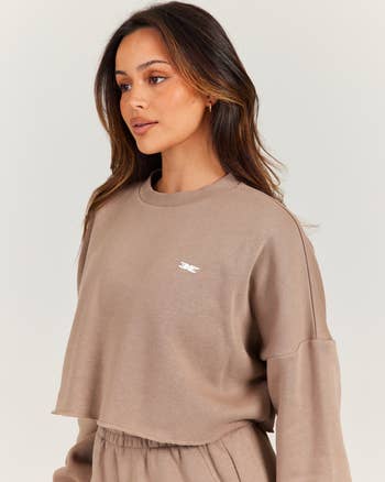 Person wearing a casual, cropped sweatshirt and pants set, suitable for a relaxed oregon  sporty look