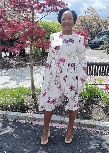 reviewer in a floral knee-length dress with three-quarter sleeves,
