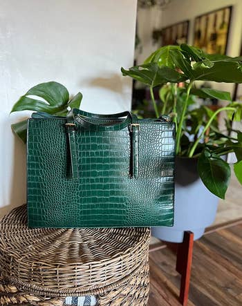 A green faux snakeskin handled bag