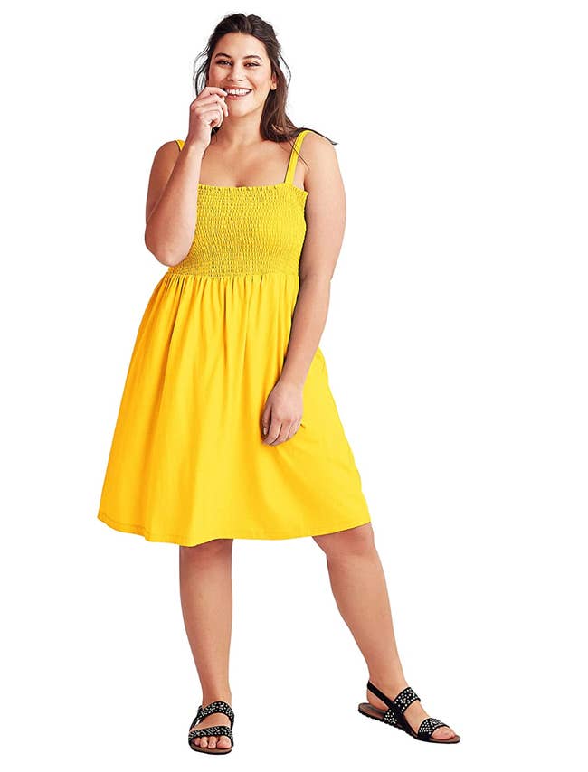 Model in a yellow smocked midi length tank dress