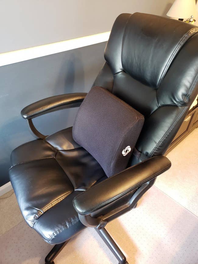 reviewer's black chair with a lumbar pillow on it