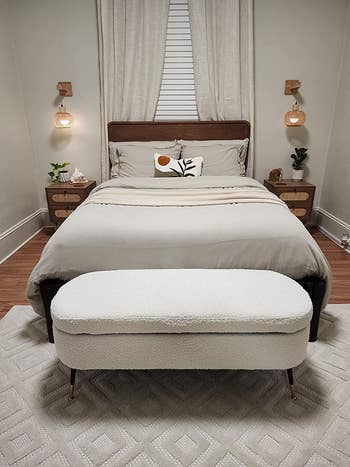 white storage ottoman at the end of a reviewer's bed
