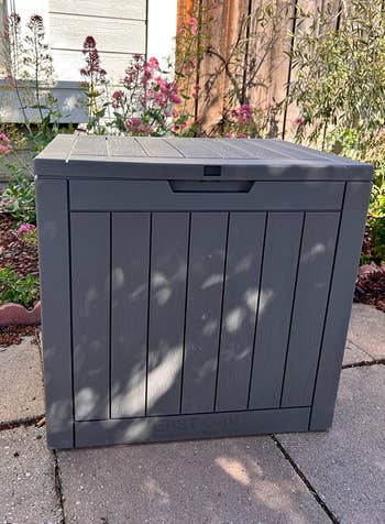 a reviewer photo of a square storage box outside 