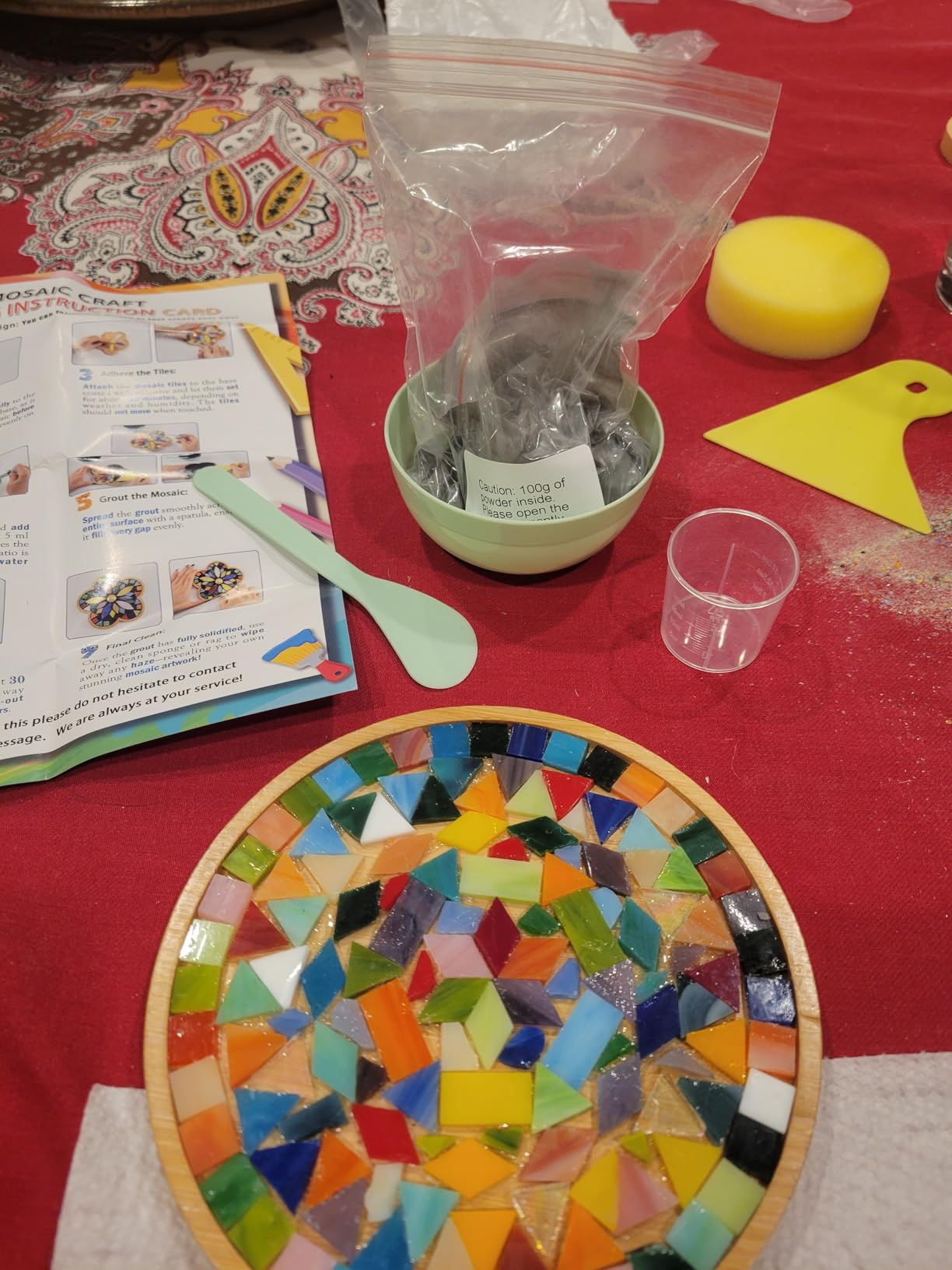 Mosaic tile kit connected  a array  with colorful tiles arranged successful  a circular pattern, tools, and instructions disposable   for a crafting project