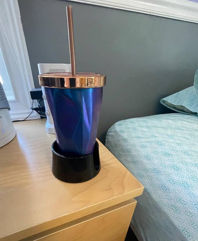 a black cupholder on a reviewer's side table