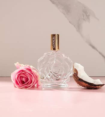 the bottle inbetween a rose and a piece of coconut