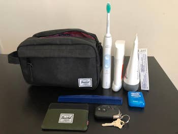 reviewer photo of all the toiletries that fit inside black Herschel toiletry bag