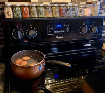reviewer's black stove shelf holding spice jars