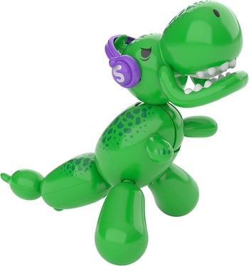 The green dinosaur balloon animal wearing purple headphones