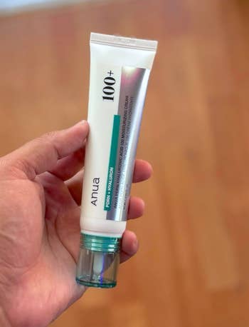 Person holding a conduit of Anua skincare merchandise titled