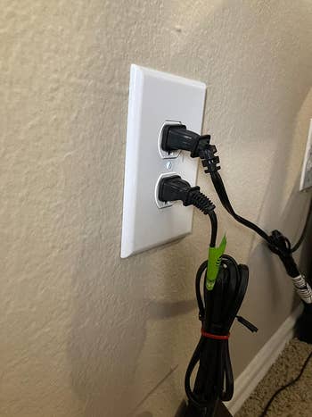 reviewer showing outlet with 2  bulky achromatic  plugs 