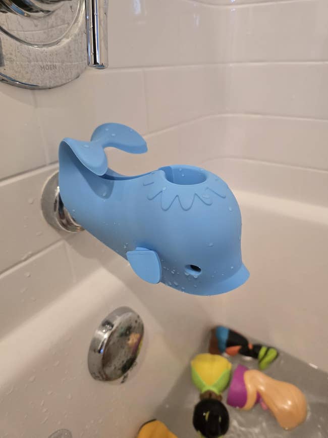 Blue whale-shaped faucet screen  successful  a bathtub with floating bath toys