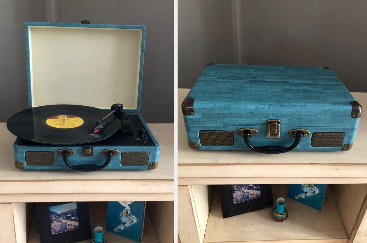 Reviewer image of blue and black suitcase portable turntable open and closed sitting on top of light wooden TV stand