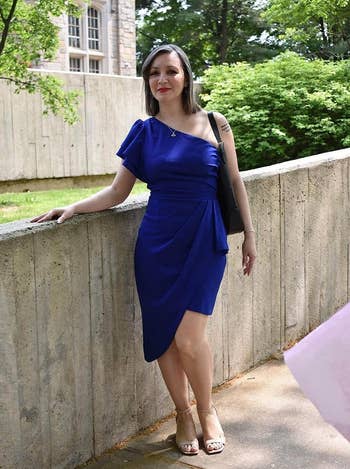 reviewer in a one-shoulder blue dress