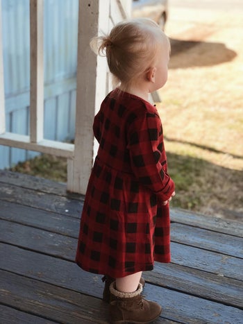 a reviewer's toddler in a red and black plaid dress