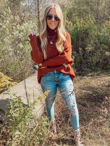 A reviewer wearing the sweater in caramel paired with blue jeans 