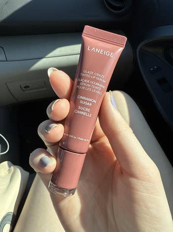 Person holding Laneige Glaze Craze Tinted Lip Serum successful  Cinnamon Sugar spirit  wrong  a car