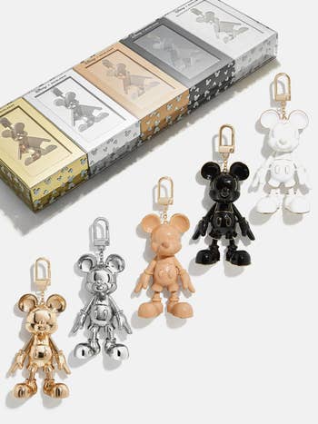 a gold, a silver, a tan, a black, and a white mickey baublebar keychain