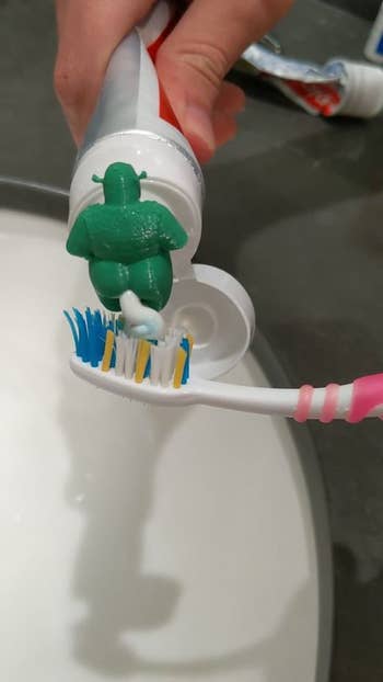 the back of the toothpaste topper with toothpaste being squeezed out of it