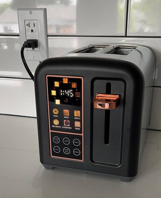 Black toaster with touchscreen settings on kitchen counter