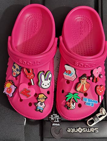 reviewer's hot pink Crocs with Bad Bunny charms on them 
