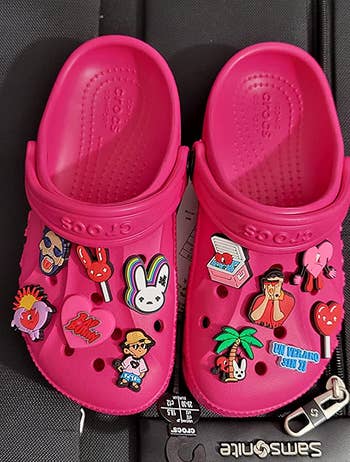 reviewer's hot pink Crocs with Bad Bunny charms on them 