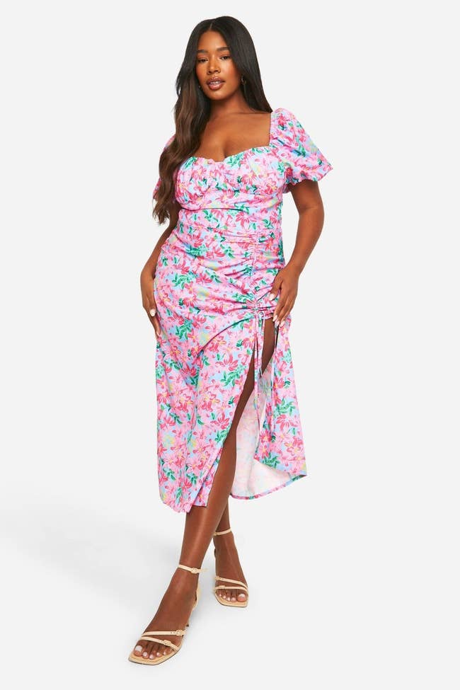 model in a floral dress with a ruched side slit and puff sleeves, wearing strappy sandals