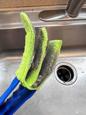 Cleaning tool with three microfiber pads, showing dirt buildup over a kitchen sink