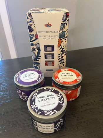 Scented candles acceptable with tins labeled Twilight Lavender, Sandalwood & Teakwood, and Orange Blossom