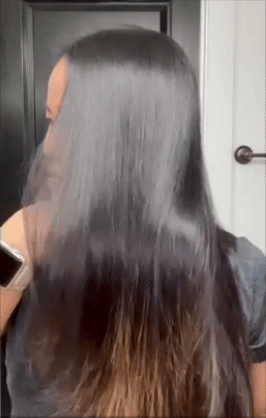 Person brushing straight, glossy hairsbreadth  successful  beforehand   of a mirror, highlighting hairsbreadth  attraction   routine