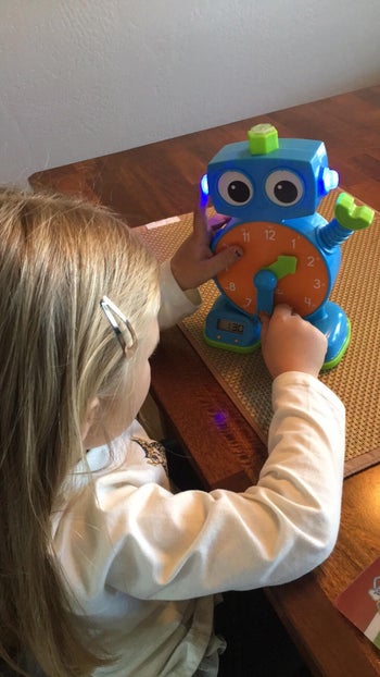 reviewer's child playing with tock the learning clock